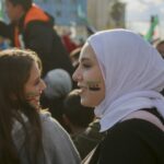 From a Lattakia Governor’s Circular to a Broader Policy Pattern: Women in the Transitional Phase Under Scrutiny Syria TV A circular issued by the Governor of Lattakia banning female employees from wearing makeup during official working hours has triggered widespread debate. Critics view the measure as an intrusion into women’s personal choices and a test of how far local authorities may go during the transitional phase. More broadly, it has revived questions about whether current decision-making aligns with the principles of equality and non-discrimination that are meant to guide state reconstruction. While some officials described the circular as a routine administrative step, activists and legal experts argue that its significance lies in a broader pattern: decisions that directly affect women are issued without their participation, without meaningful representation in positions of influence, and without adequate consideration of their legal, social, or economic impact. Disputed Authority Lawyer Soufana Khalil told Syria TV that the circular is “illegal,” issued without jurisdiction or legal basis. She said it violates the constitutional declaration for the transitional phase, entails gender-based discrimination, and infringes on personal freedom and human dignity. Khalil argued that the measure is legally void and open to challenge, and that no administrative penalties may be imposed under it. Although temporary constitutional texts affirm equality and non-discrimination, she noted that these principles remain ineffective without clear enforcement and oversight mechanisms. Their absence, she warned, enables local decisions that contradict the spirit of equality without meaningful accountability. Women and Decision-Making Feminist activist Hiyam Haj Ali described women’s representation in transitional institutions as “embarrassingly low.” Previous efforts aimed to secure at least 30 percent representation to ensure women’s participation in public debate and policymaking. The results so far, she said, fall short of those commitments. She argued that excluding women from decision-making weakens political life, undermines institutional legitimacy, and marginalises women’s needs in legislation and policy. Women’s representation in the People’s Assembly, she noted, was left to presidential discretion rather than embedded in binding electoral rules, turning representation into a matter of political will rather than a guaranteed right. The head of the elections committee, Mohammad Taha al-Ahmad, attributed women’s “limited” participation to prevailing social customs. Observers counter that framing the issue as cultural alone risks excusing the absence of structural remedies such as quotas or political empowerment programmes. Activists say this reflects an approach that treats women’s participation as a file managed from above rather than a legal entitlement. Data from the Karam Shaar Advisory and Studies Center show that women constitute only 4.9 percent of elected members (6 out of 122), down from 11.2 percent in the 2020 parliament. Women made up just 14.1 percent of candidates. The center cited entrenched social barriers and procedural flaws, noting that the Higher Elections Committee included only two women among eleven members and that candidate-selection bodies were overwhelmingly male. From Policy to Practice Administrative measures that marginalise women extend beyond symbolic control of appearance. They contribute to pushing women out of the formal labour market and limiting access to stable income and economic independence. In a context where many women are heads of household after years of war, hostile work environments risk deepening vulnerability rather than supporting recovery. Doaa, a former employee, said workplace pressures have intensified. “When my temporary contract ended, I chose not to renew it. The psychological and professional pressure became unacceptable,” she said. Salma, who supports her family, now works in unstable conditions in a local market. “This exclusion systematically reproduces poverty and places me under double pressure,” she explained. Leila left institutional work after enduring scrutiny and comments about her clothing, opting instead for less stable independent work. Legal Restrictions Beyond the Workplace Controversy has also surrounded Circular No. 17 of 2025 issued by the Ministry of Justice, which critics say limits a mother’s independence in managing her children’s affairs. Hajar said the measure revived fears she believed she had overcome and made her reconsider returning to Syria. Instead of strengthening justice, she argued, such texts risk placing women’s rights under discretionary authority. A Broader Pattern Studies indicate that Syrian women face intersecting legal, social, and economic vulnerabilities in the post-regime period, affecting education, employment, and mental health. Weak legal protections and limited access to formal work continue to push many into informal sectors with unstable wages and few safeguards. Taken together, the Lattakia circular and similar measures suggest more than isolated incidents. They point to an unsettled question at the heart of the transitional phase: whether women will be treated as full citizens with guaranteed rights, or whether old imbalances will reappear in new forms.